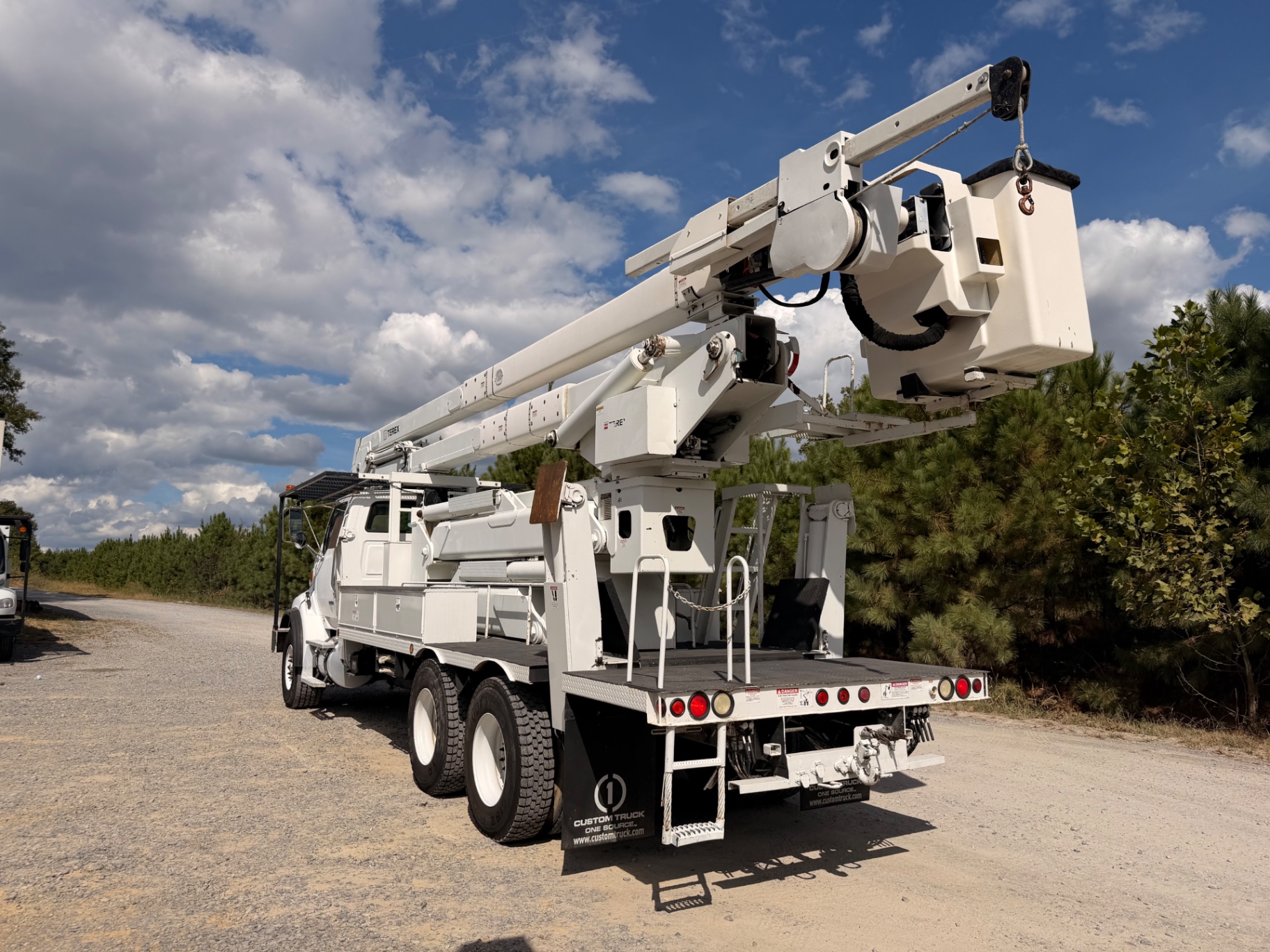 Rear-side view of raised bucket and Terex equipment